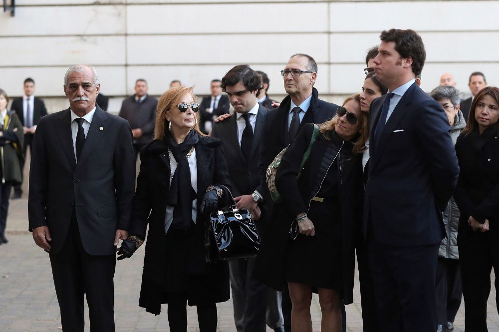El hijo de José Manuel Maza (d), José Maza, y la viuda Marta Raspall (3d),junto a otros familiares en la entrada a la capilla ardiente del fiscal general del Estado.