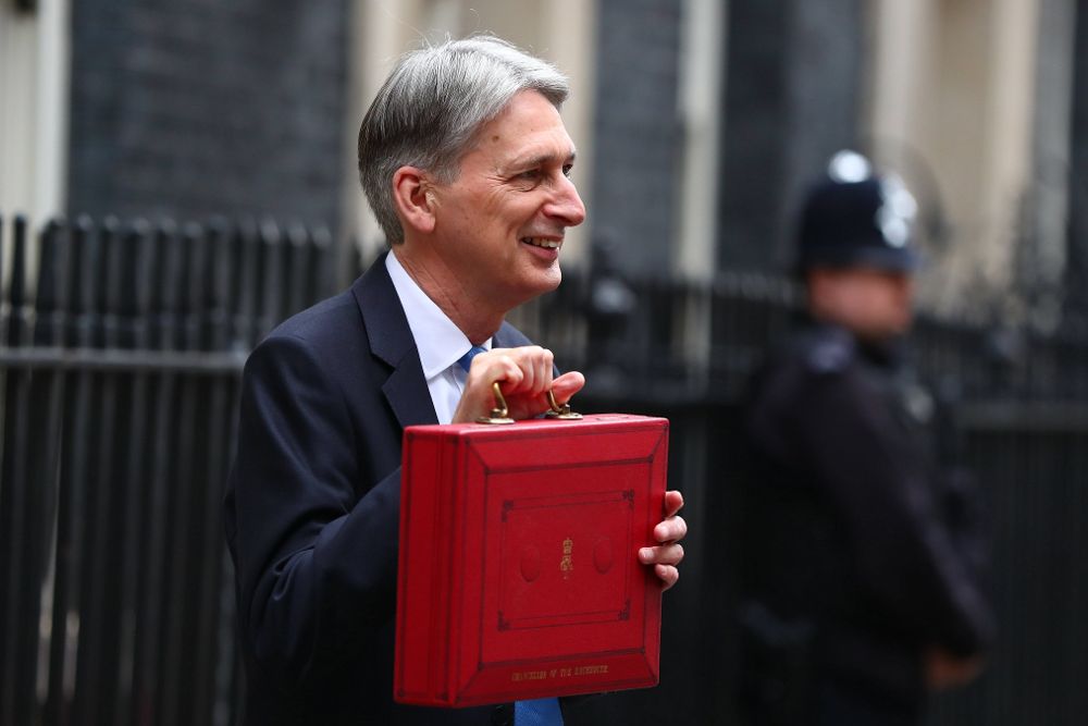El ministro de Hacienda del Gobierno británico, Philip Hammond, muestra el maletín rojo de los presupuestos en el número 11 de Downing Street en Londres (Reino Unido).