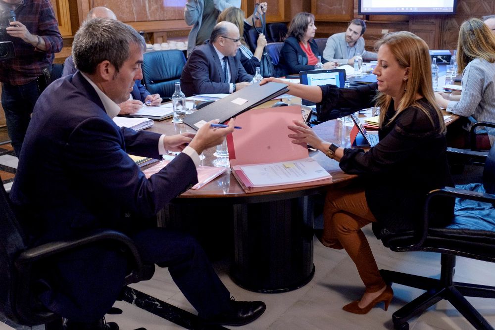 El presidente del ejecutivo regional, Fernado Clavijo, y la consejera de Hacienda, Rosa Dávila, intercambian unos portafirmas, momentos antes de iniciarse la reunión del Consejo de Gobierno.
