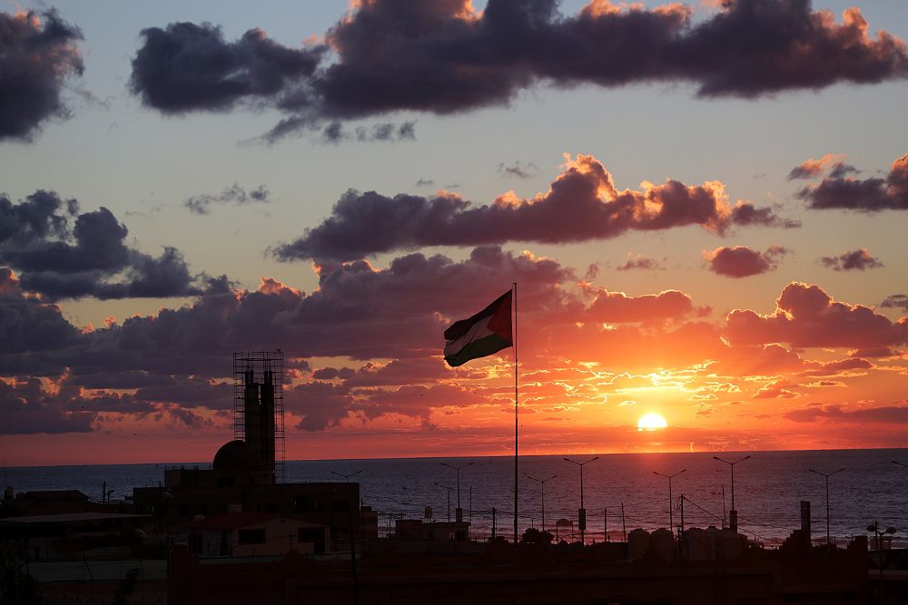 Una bandera palestina ondea durante el atardecer en la Franja de Gaza.
