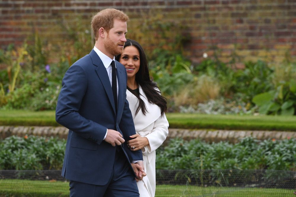 El príncipe Enrique de Inglaterra posa junto a su prometida, la actriz estadounidense Meghan Markle, tras anunciar su compromiso en el Jardín Sunken del Palacio Kensington, en Londres.