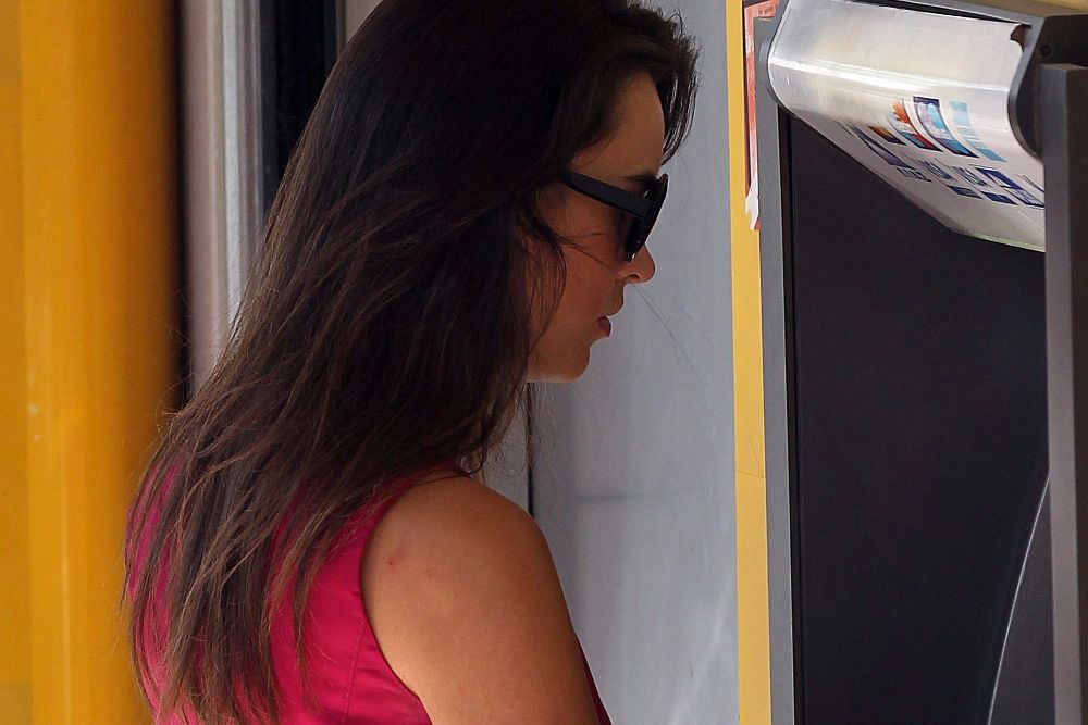Una mujer ante un cajero automático.