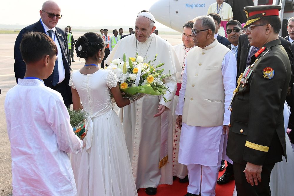 El papa Francisco (c), acompañado por el presidente de Bangladesh, Abdul Hamid (2-dcha), recibe flores a su llegada al Aeropuerto Internacional de Daca.