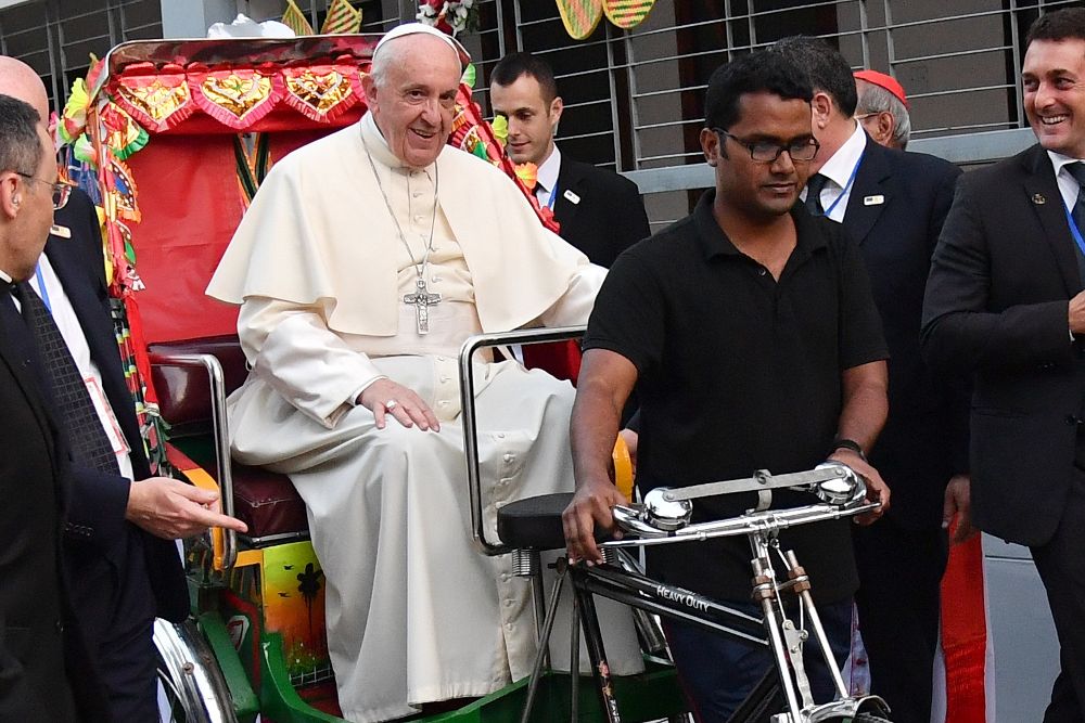 El papa Francisco (izq) montado en un "rickshaw".