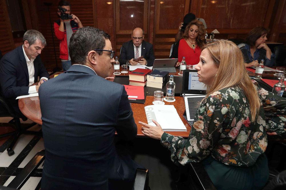 El vicepresidente del Gobierno de Canarias, Pablo Rodríguez (2i), habla con la consejera de Hacienda, Rosa Dávila, durante la reunión del consejo de gobierno de hoy.