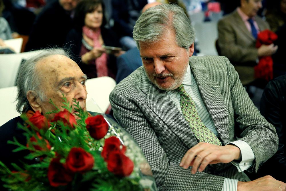 El escritor Rafael Sánchez Ferlosio, con un ramo de rosas, junto al ministro de Educación, Cultura y Deporte durante el acto en el que el escritor ha sido homenajeado. 