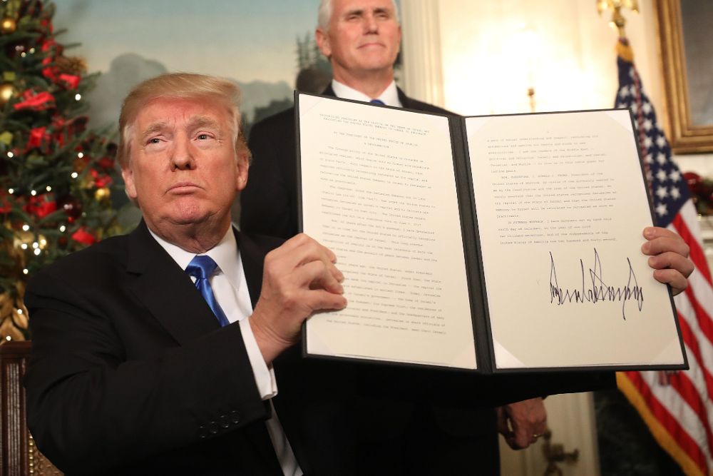 El presidente de EE.UU., Donald Trump, firma su proclamación en la sala de recepciones diplomáticas de la Casa Blanca con la que confirmó que su país reconocerá a partir de ahora a Jerusalén como capital de Israel.