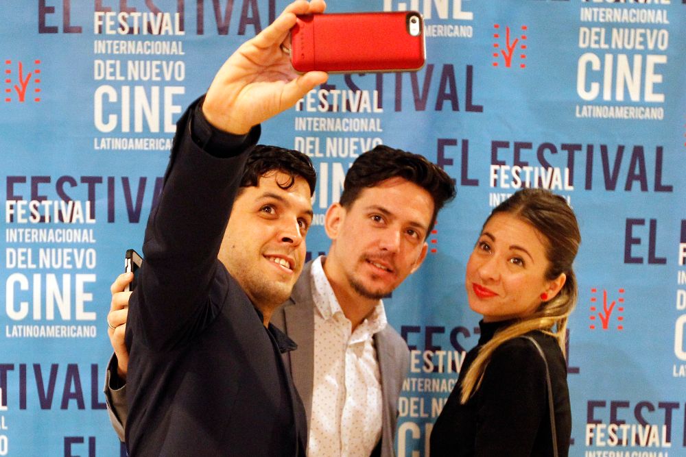 Tres personas se sacan una foto durante la inauguración del 39º Festival Internacional de Cine Latinoamericano de La Habana.