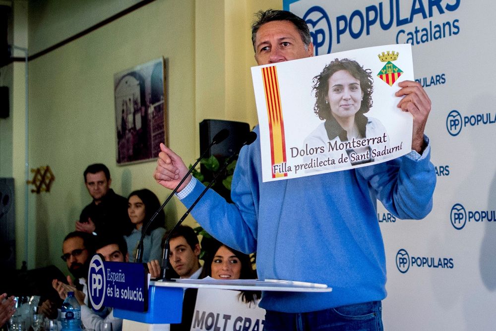 El presidente del PPC y candidato a la presidencia de la Generalitat, Xavier García Albiol, muestra un cartel con la imagen de la ministra de Sanidad, Dolors Montserrat, mientras participa en un almuerzo-mitin en Sant Sadurní.