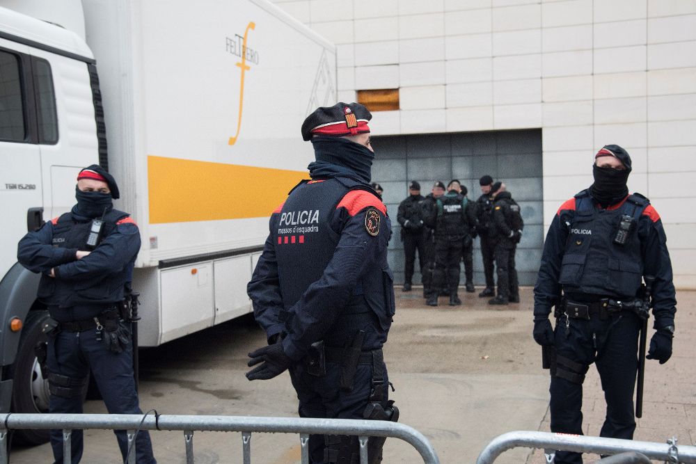 Los mossos vigilan la operación de carga atentos a los manifestantes que se concentran fuera del Museo de Lleida para intentar dificultar el traslado de los obras.