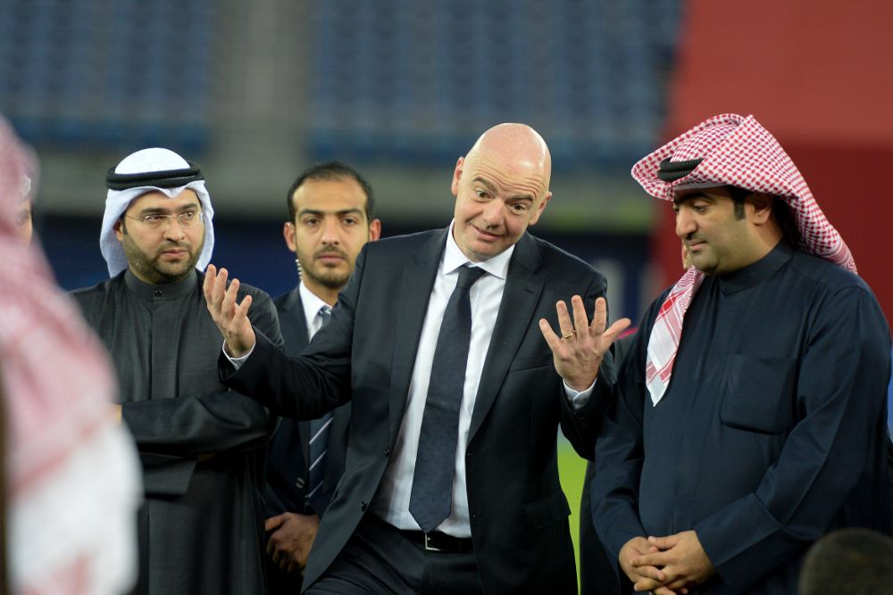 El presidente de la FIFA, Gianni Infantino (c-d), habla con jóvenes jugadores de fútbol en el Jaber Al-Ahmad International Stadium durante su visita a Kuwait.