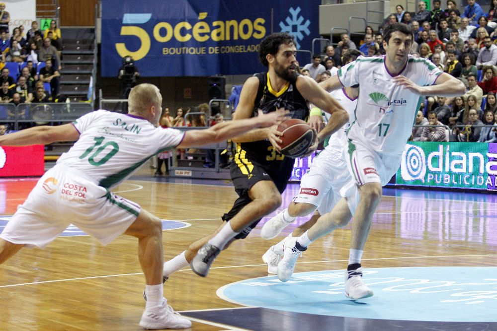 El alero del Iberostar Tenerife, Javier Beirán (c), supera a Sasu Salin (i) y Giorgi Shermadini, de Unicaja, durante el partido de Liga ACB que Iberostar Tenerife y Unicaja Málaga juegan esta tarde en Tenerife.