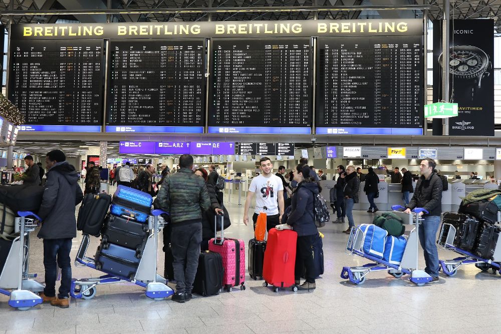 Pasajeros observan los paneles de información de vuelos en el aeropuerto de Fráncfort en Alemania hoy, 18 de diciembre.
