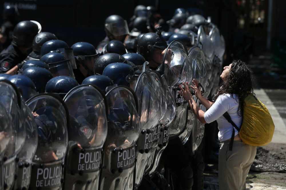 Una manifestante enfrenta a integrantes de la Policía Federal.