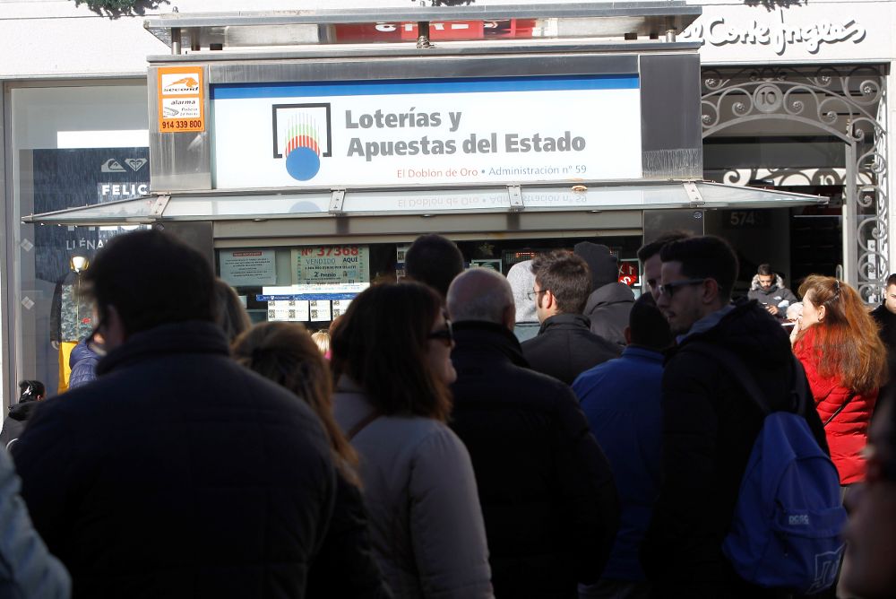 Vista de las colas de gente en la administración de Loterías y Apuestas del Estado "El Doblón de Oro", ubicado en la Puerta del Sol de Madrid.