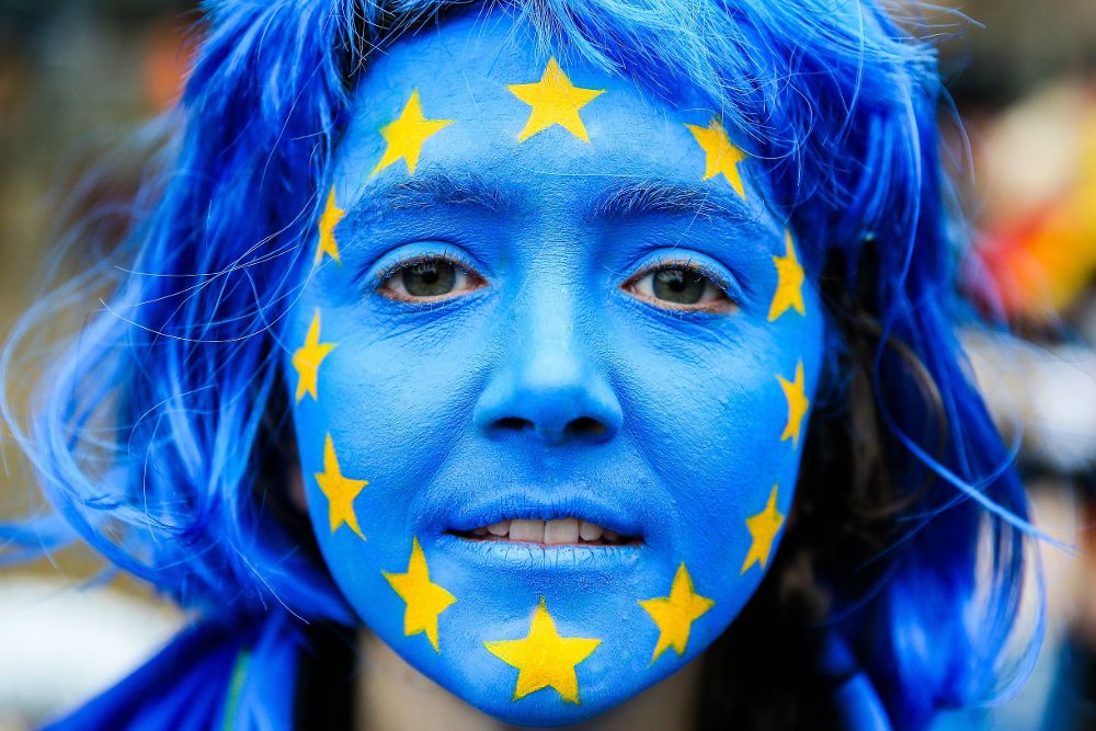 Una mujer con la cara pintada con la bandera de la Unión Europea.