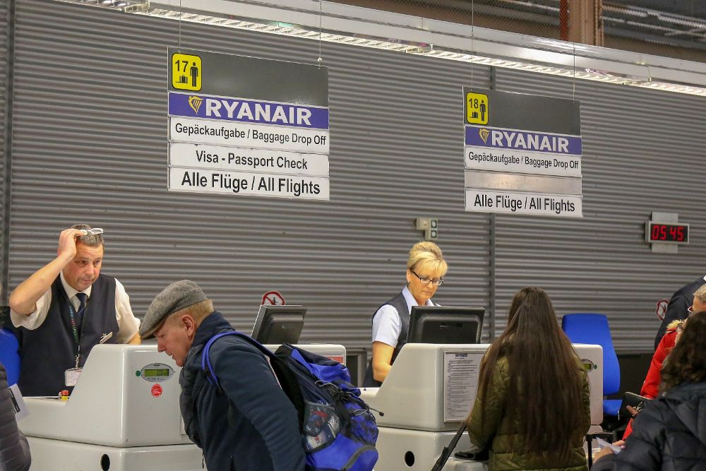 Viajeros facturan su equipaje en un mostrador de la aerolínea Ryanair en el aeropuerto de Fráncfort-Hahn durante la huelga de advertencia de los pilotos de la aerolínea irlandesa.