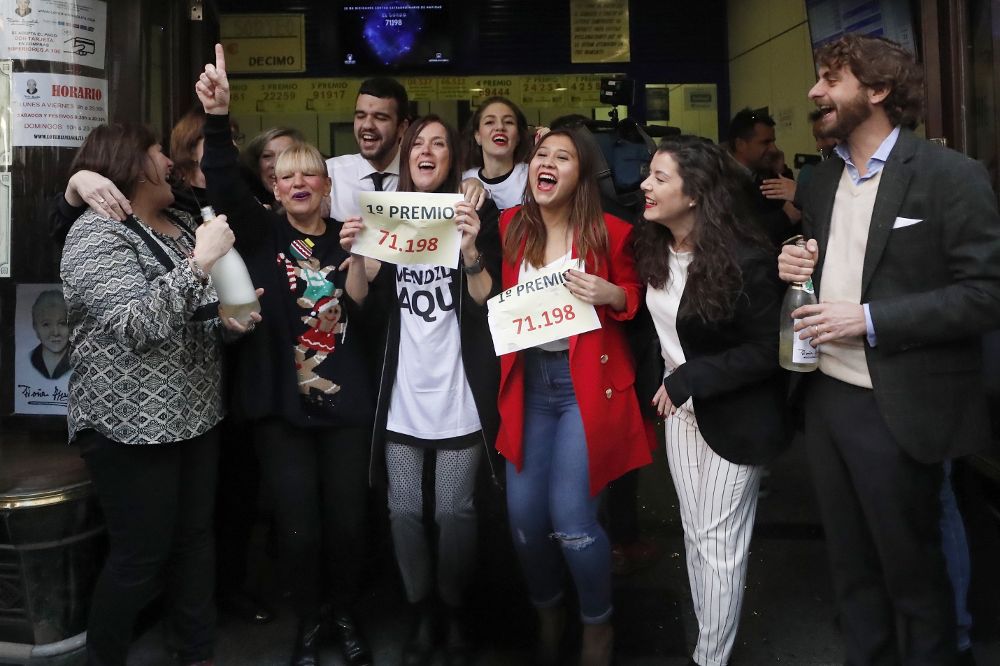 La Administración de lotería " Doña Manolita" en la calle del Carmen en Madrid, celebran haber vendido el número 71.198 que ha sido agraciado con el Gordo de Navidad.