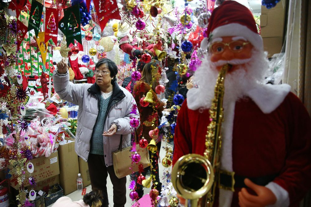 Una mujer compra objetos de decoración navideña en una tienda de Pekín.