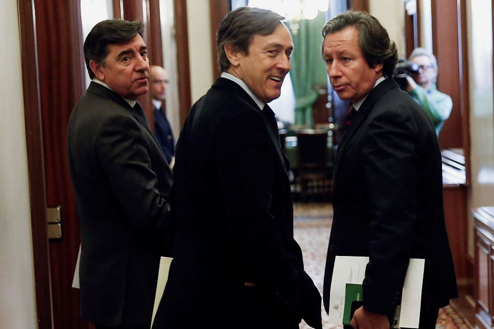 El portavoz del Grupo Popular, Rafael Hernando (c), acompañado de dos compañeros, en los pasillos del Congreso.