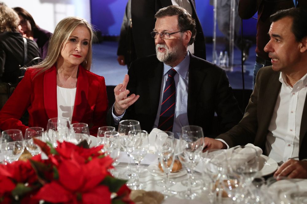 El presidente del Gobierno y del PP, Mariano Rajoy (c), junto a la presidenta de la Comunidad, Cristina Cifuentes, y el coordinador general el PP, Fernando Martínez Maíllo (d), durante la cena de navidad del PP de Madrid.