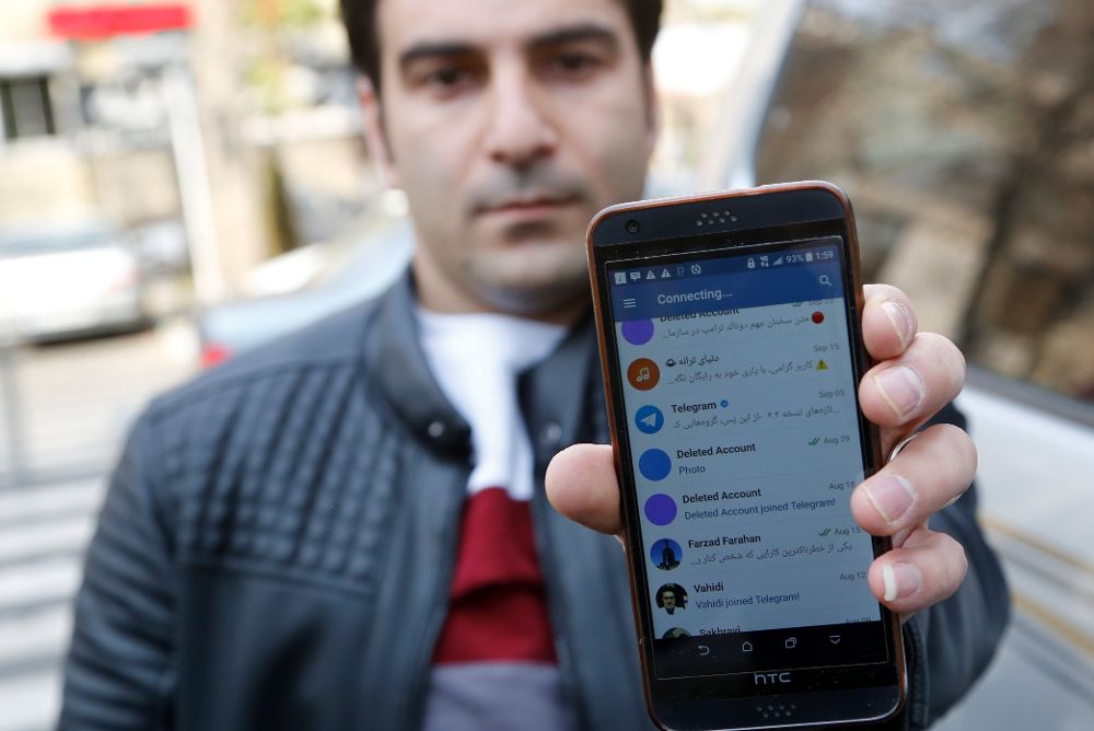 Un hombre muestra su teléfono inteligente que intenta, sin éxito, conectarse con una red social en Teherán (Irán).