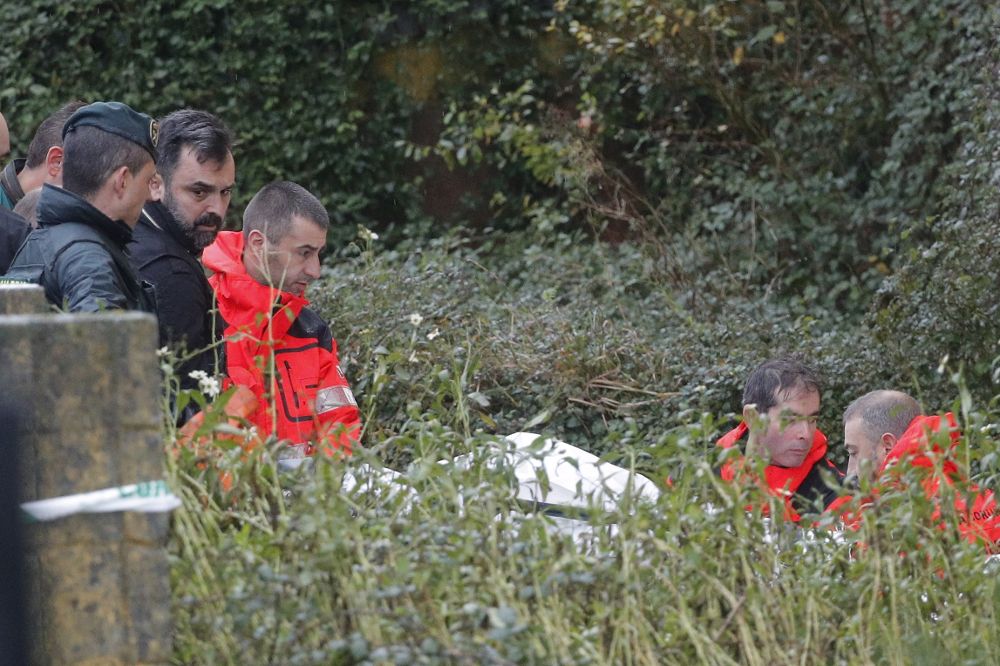 Efectivos de la Guardia Civil y bomberos trasladan en una camilla los restos del cadáver de Diana Quer.