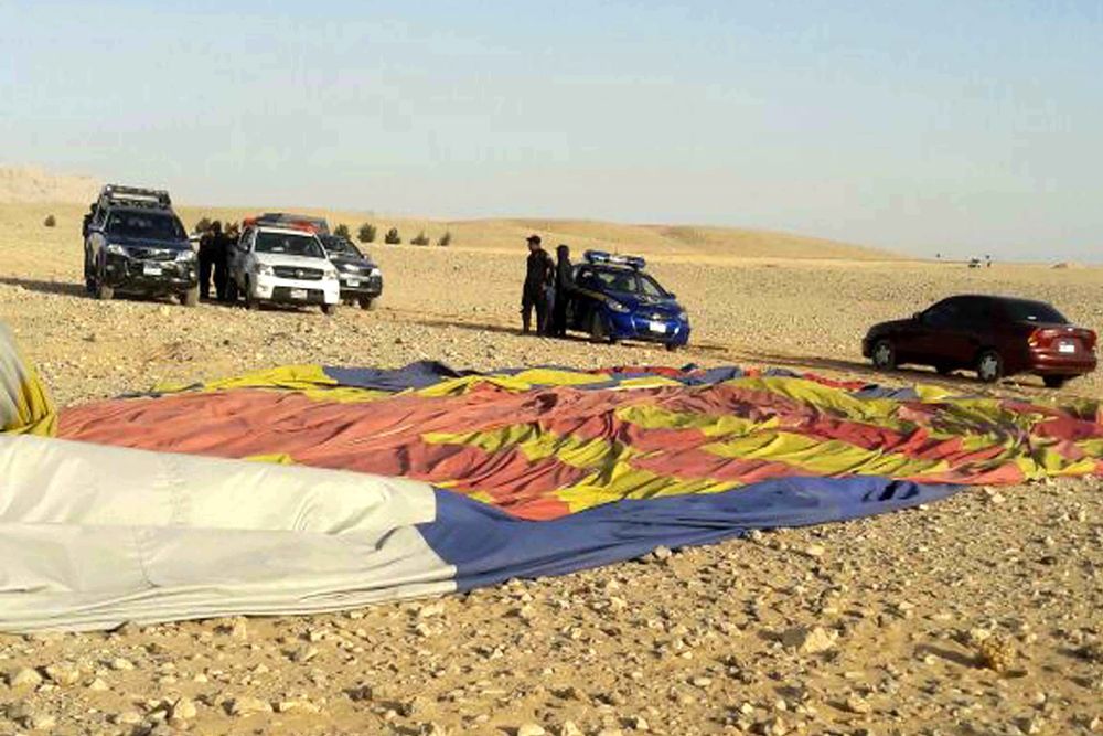Agentes de policía permanecen en el lugar donde se estrelló un globo aerostático en Luxor, Egipto.