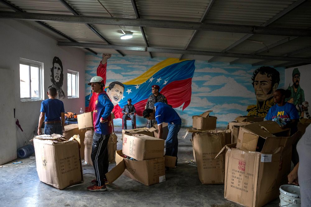 Un grupo de personas adeptas al oficialismo saca juguetes de una Casa de Asambleas del Poder Popular para repartirlos en el sector La Vega.