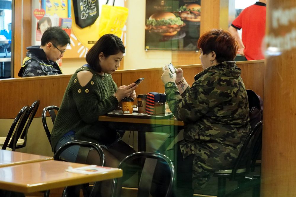 Dos personas consultan su teléfono en un restaurante de Taipei (Taiwán).