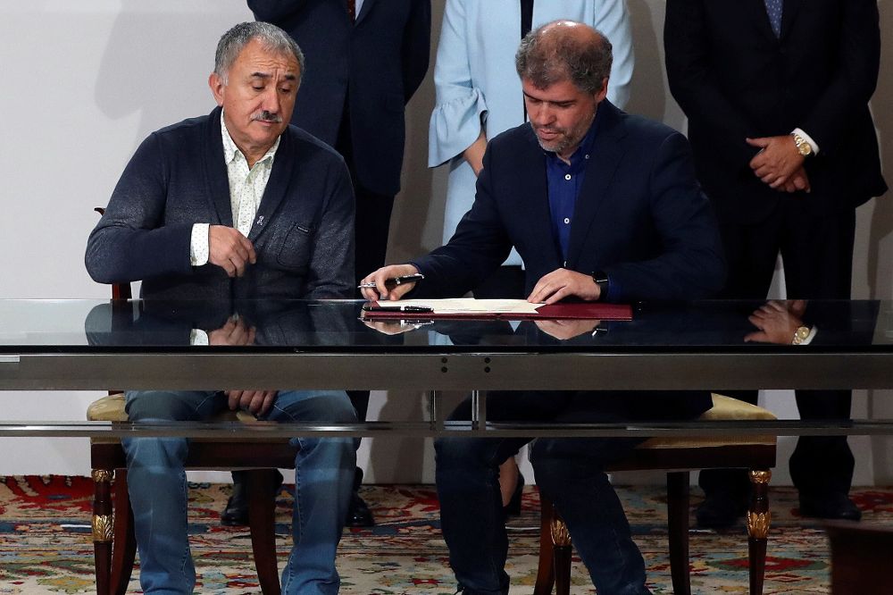 Los secretarios generales de CCOO y UGT, Unai Sordo (d) y Pepe Álvarez, durante la firma del acuerdo social para la subida del salario mínimo interprofesional, el 26 de diciembre.