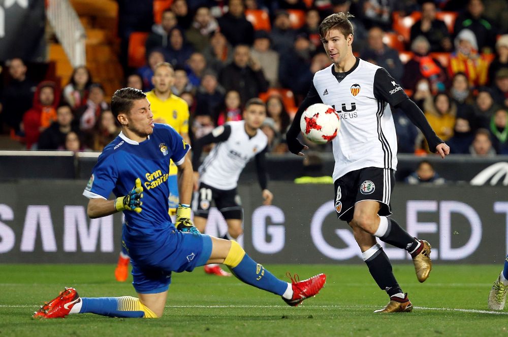 El delantero argentino del Valencia Luciano Vietto (d) marca el segundo gol ante el portero de la UD Las Palmas.