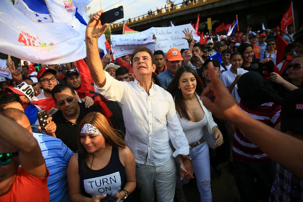 El excandidato presidencial hondureño de la Alianza de Oposición contra la Dictadura, Salvador Nasralla (c), participa en una marcha justo a su esposa Iroshka Elvir (d).