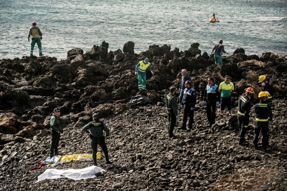 Efectivos policiales y bomberos en la playa Bastián de Costa Teguise, adonde llegó la patera.