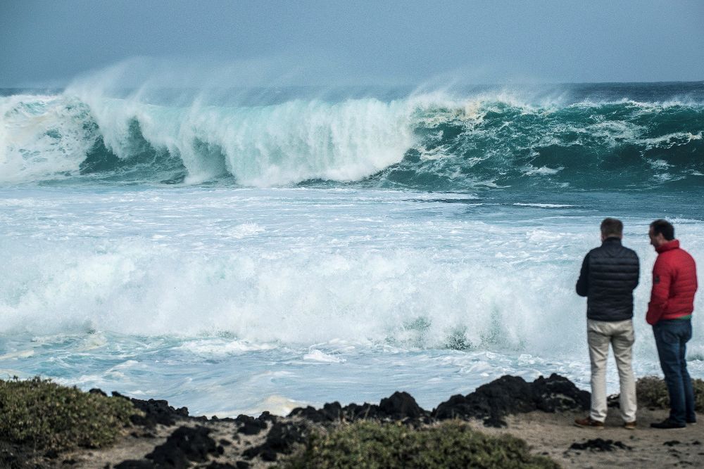 Dos hombres observan el fuerte oleaje en la zona de Jameos del Agua, al norte de Lanzarote.