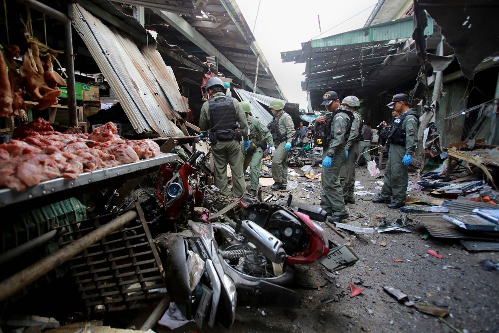 Policías expertos en explosivos inspeccionan el escenario de los hechos después del atentado.