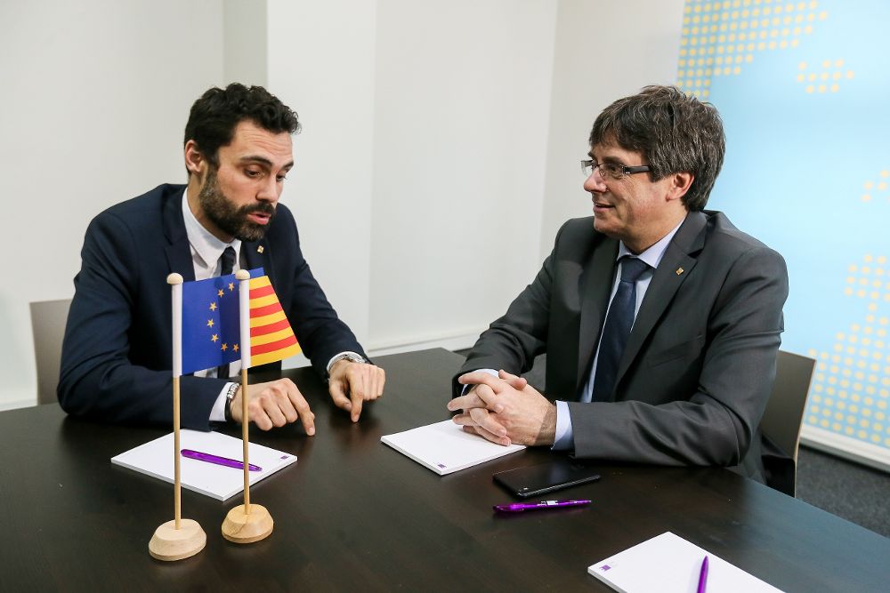 El expresidente de la Generalitat Carles Puigdemont (d) conversa con el presidente del Parlamento autónomo, Roger Torrent, durante su reunión en Bruselas.