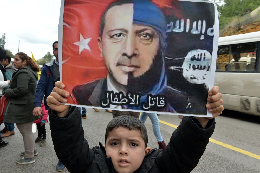Un niño kurdo sostiene una pancarta con la imagen del presidente turco, Recep Tayyip Erdogan, durante una protesta.