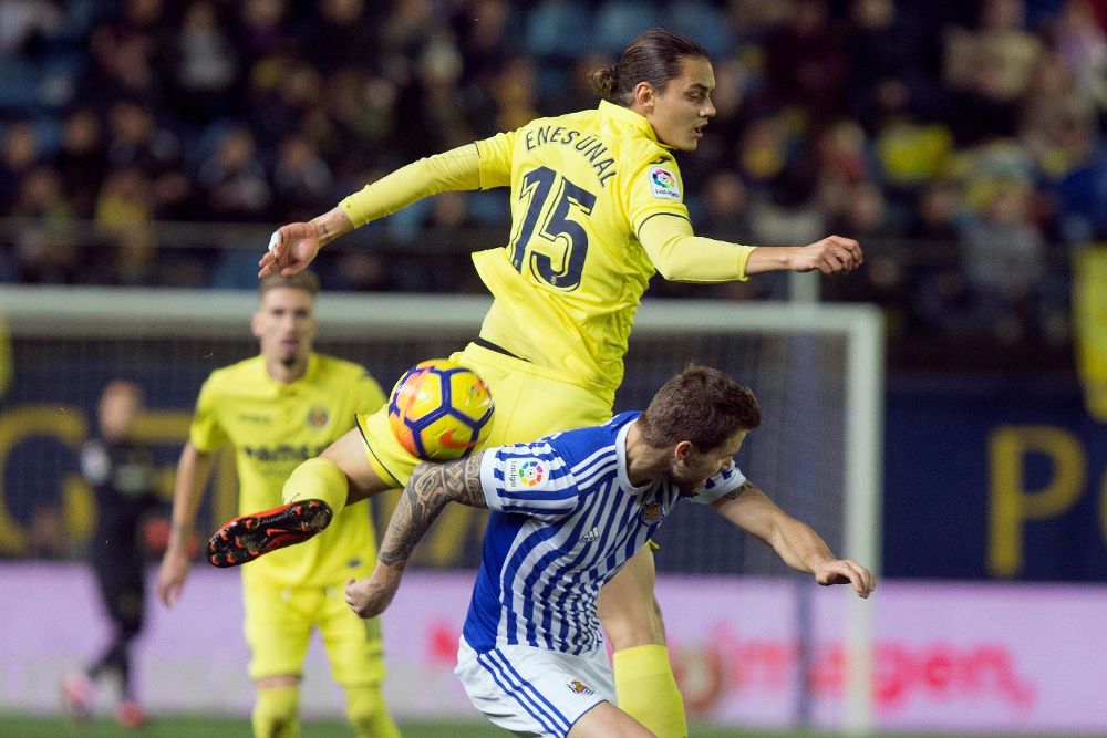 El delantero turco del Villarreal Enes Unal (arriba) pelea un balón con el centrocampista de la Real Sociedad Íñigo Martínez.