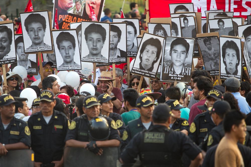 Manifestantes muestran carteles con los rostros de las víctimas de las matanzas por las que fue condenado Fujimori.