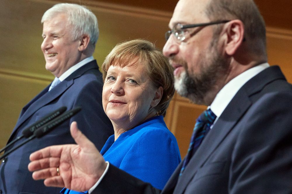 Angela Merkel (c), su socio conservador bávaro Horst Seehofer (i), y Martin Schulz.