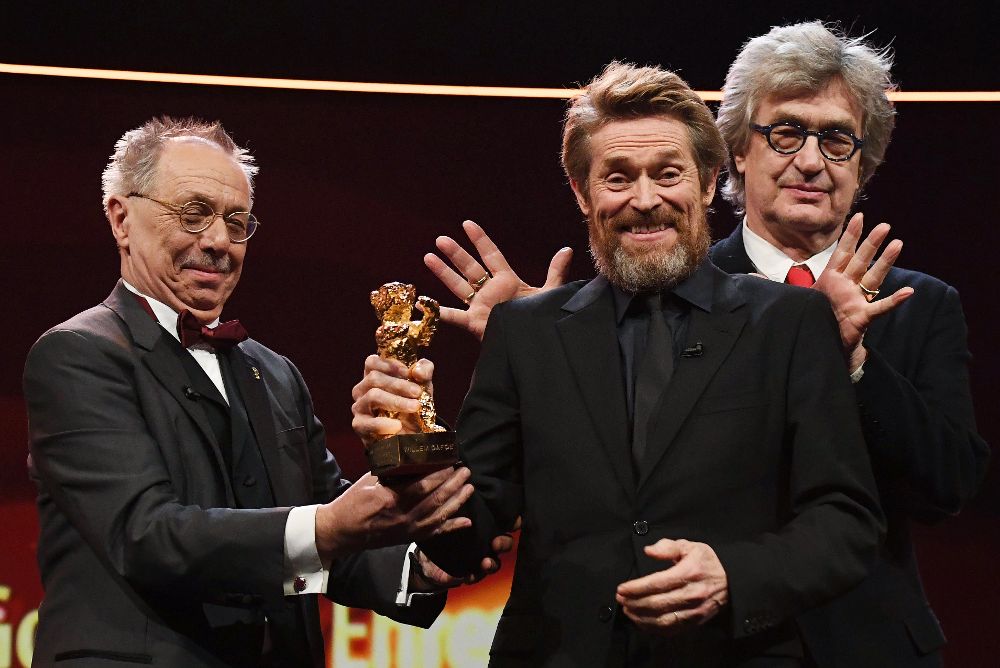 El actor estadounidense Willem Dafoe (c) recibe el premio Honorary Golden Bear durante un homenaje en su honor junto al director del festival Dieter Kosslick (i) y el director Wim Wenders.