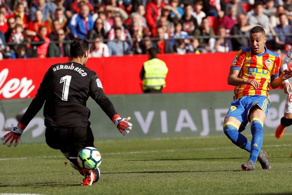 El delantero del Sevilla Rodrigo Moreno dispara y marca al portero del Valencia, Sergio Rico.