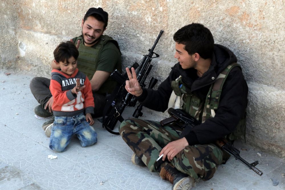 Soldados sirios con un niño en Guta Oriental.