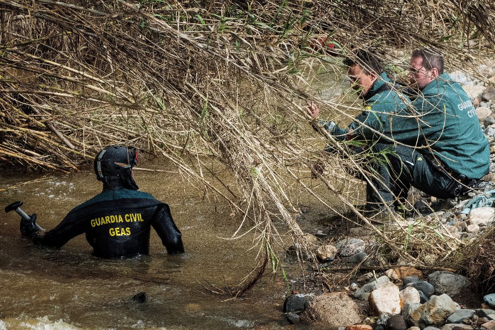 Miembros de la Guardia Civil, ayer, durante las labores de búsqueda en el arroyo donde desapareció su compañero.