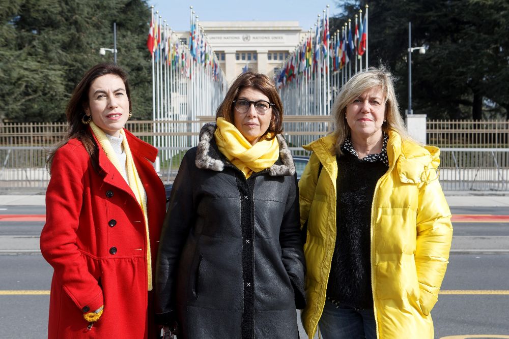 La novia de Jordi Cuixart, Txell Bonet (i), la mujer de Joaquim Forn, Laura Masvidal (c), y la hermana de Toni Comin, Betona Comin, posan para medios de comunicación en Place des Nations ante la sede europea de las Naciones Unidas en Ginebra (Suiza).