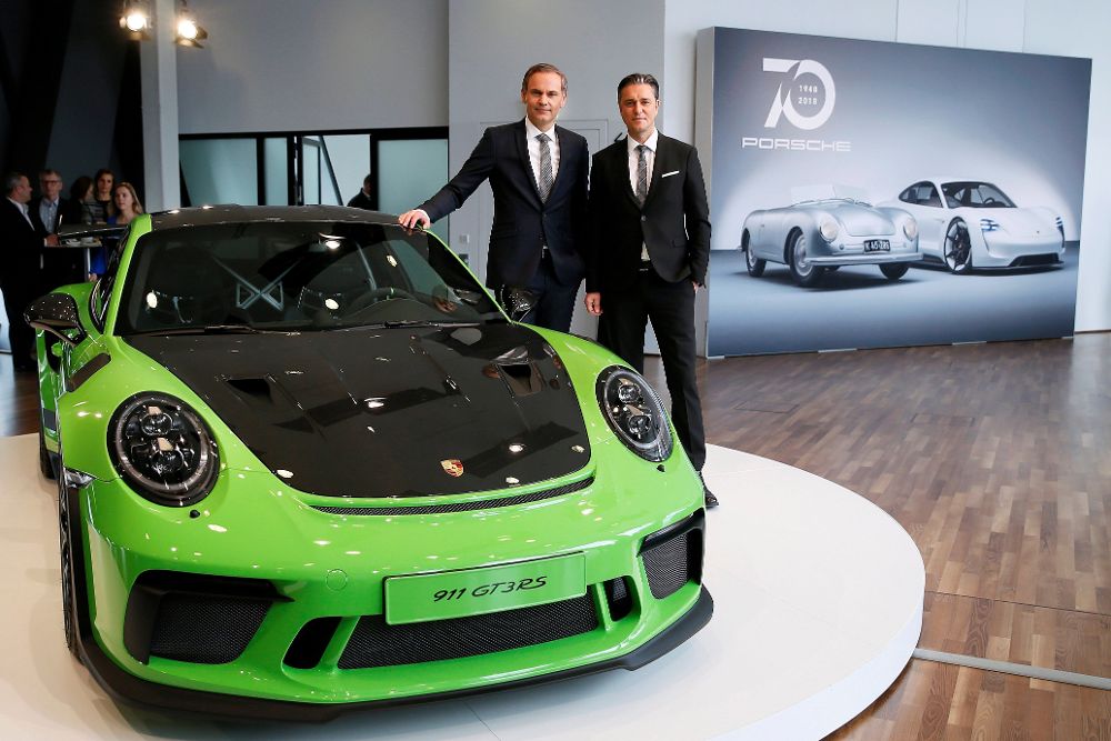El primer ejecutivo de Porsche, Oliver Blume (i), y el director financiero, Lutz Meschke (d), posan junto a un Porsche 911 GT3RS.