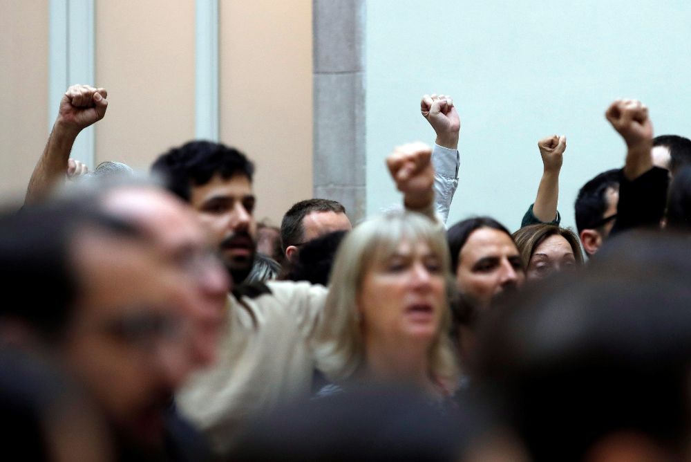 Algunos diputados levantan el puño mientras se entona el himno catalán tras la declaración institucional que el presidente del Parlament, Roger Torrent.
