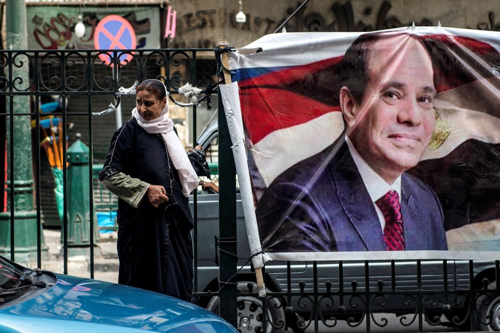 Una mujer camina junto a un cartel con la imagen de Abdelfatah al Sisi, en El Cairo.