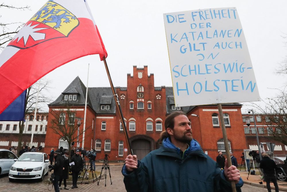Un hombre sujeta un cartel con el mensaje "La libertad de los ciudadanos catalanes cuenta también en Schleswig-Holstein" frente a la cárcel de la localidad de Neumünster en la que que está Carles Puigdemont .